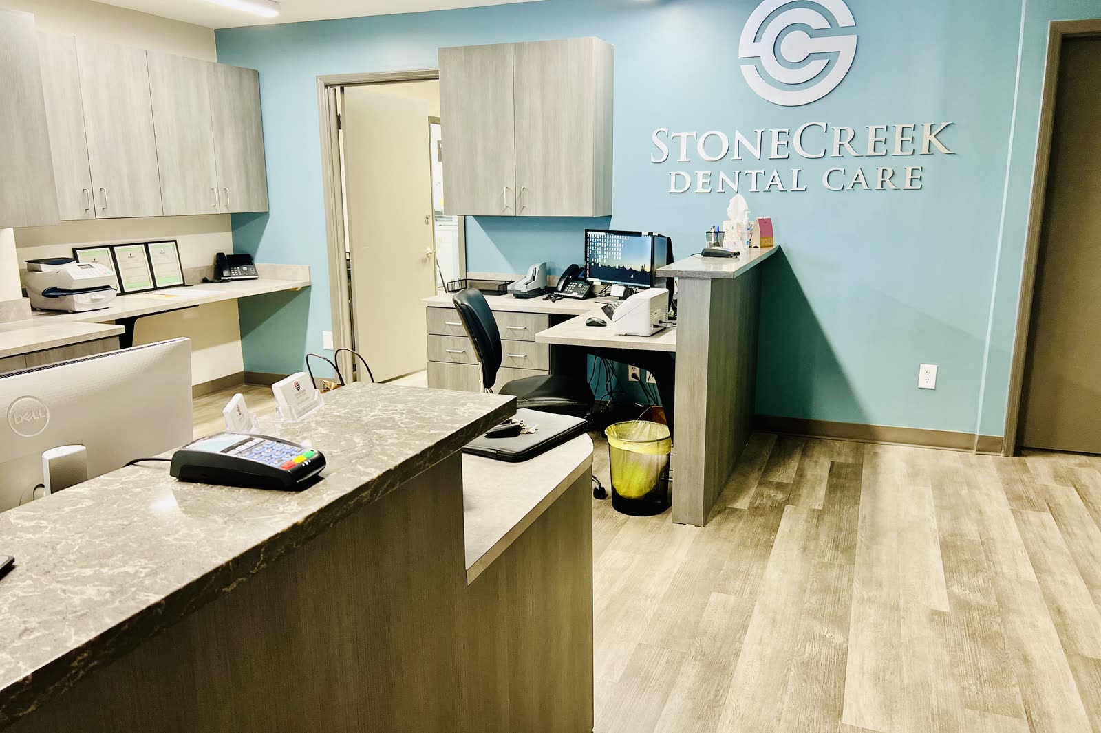 Front desk with the StoneCreek Dental Care name and logo on the wall behind it