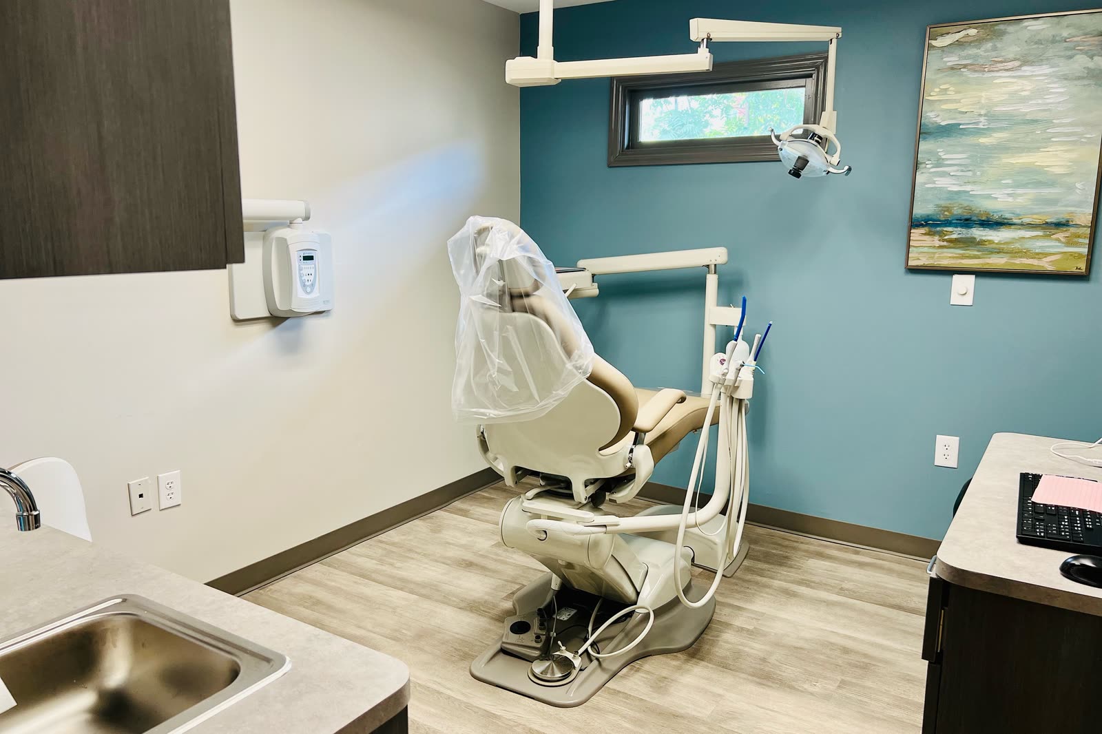 Treatment room with a dental chair, overhead lamp and x-ray unit